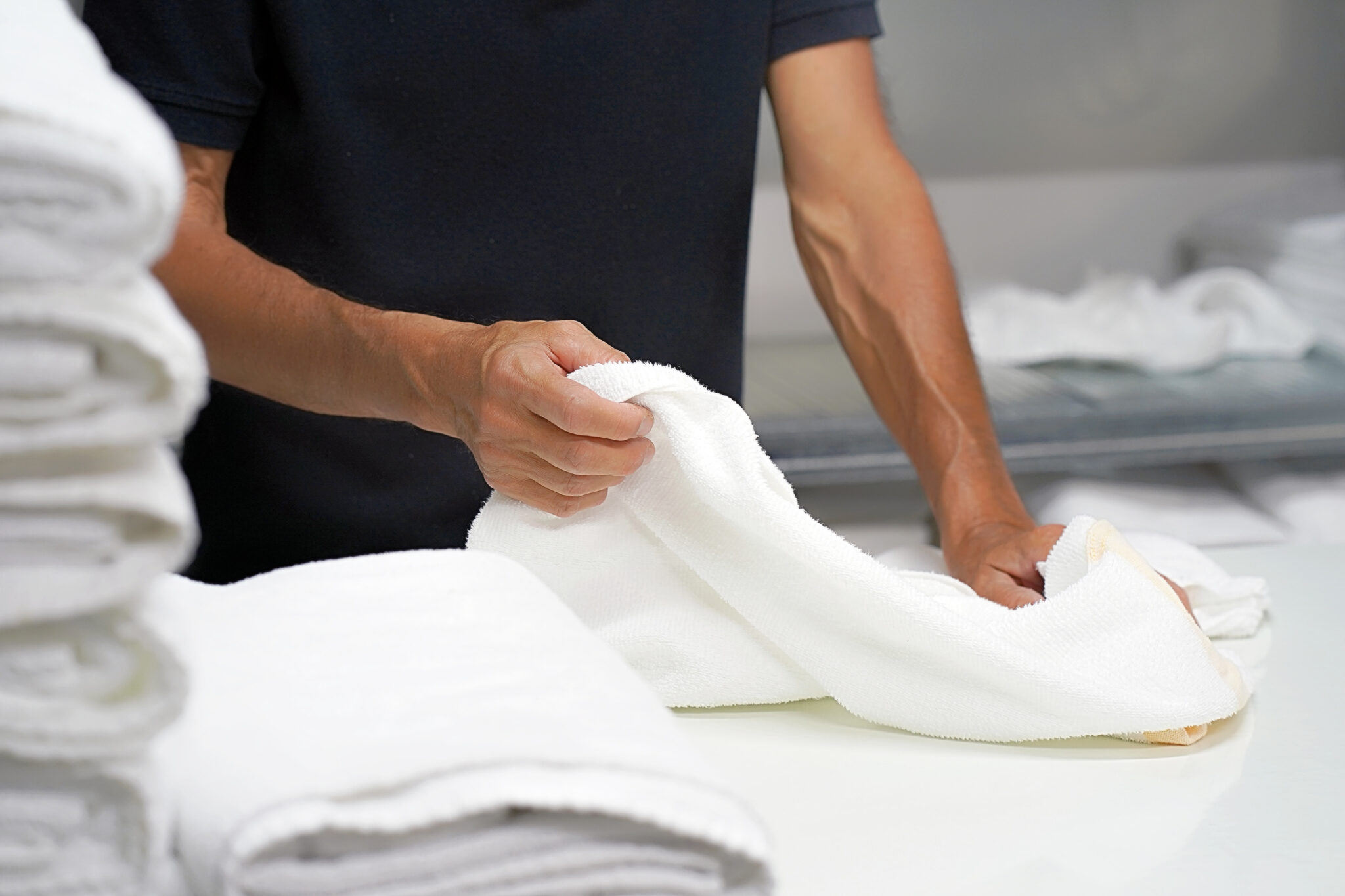 Laundry hotel. A man lays out a white towel.
